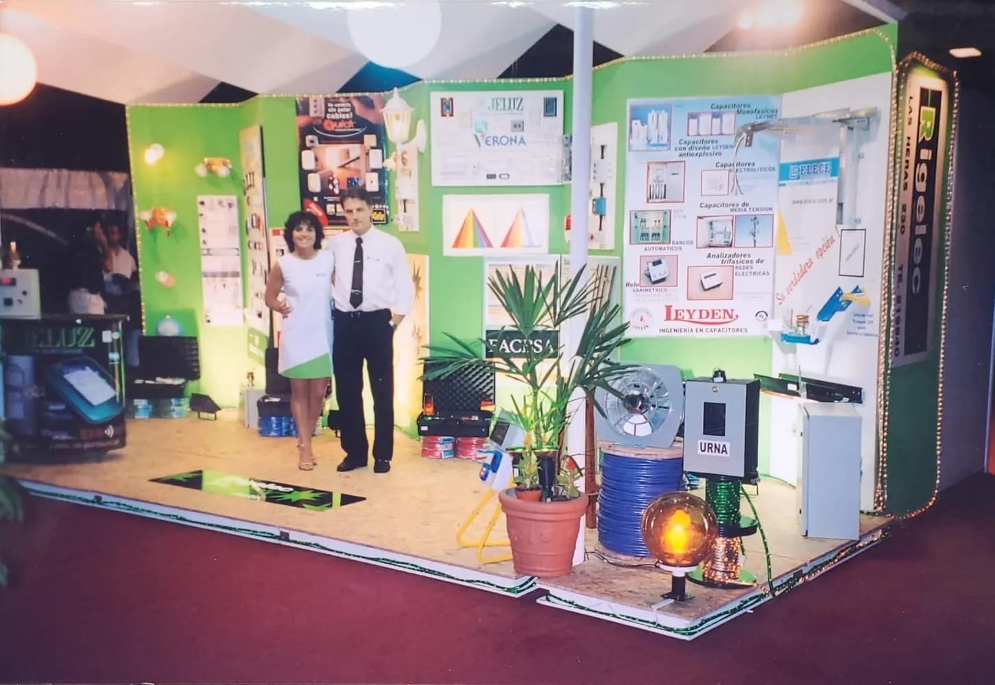 Stand de Rigelec en una exposición, con paneles de producto e iluminación